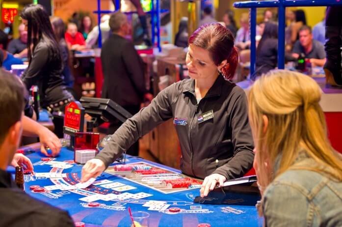 Casino employee giving cards at a baccarat table